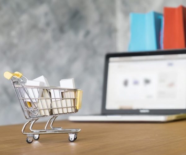 Business theme, internet online shopping concept, shopping delivery, shopping cart carry shopping mail box and blur background of shopping bag and open laptop
